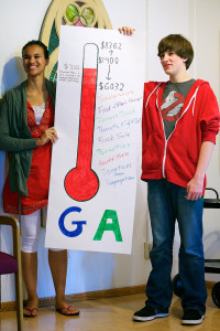 Two people holding up fundraising sign